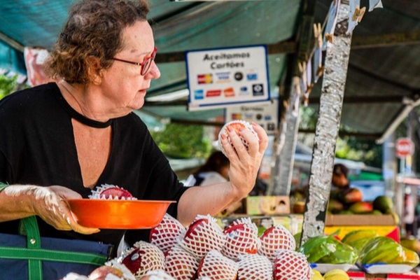 Sao Paulo, Brazil - A customer buying apples on sale at a fruit stall in a street market in Sao Paulo.